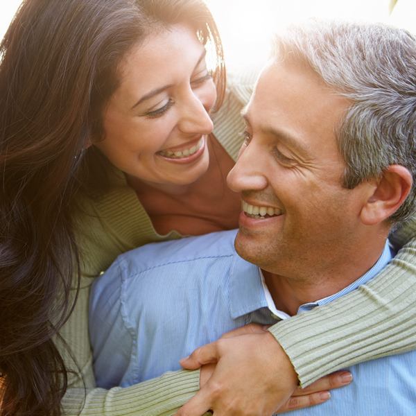 Middle aged couple is smiling and hugging