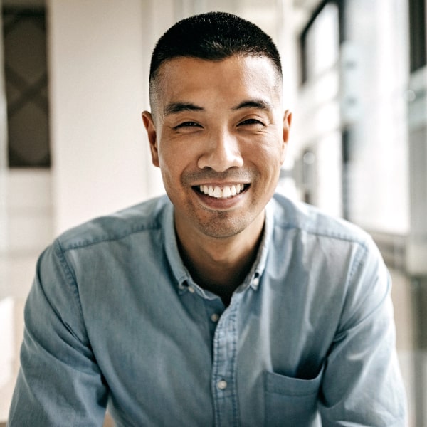 A man in a gray shirt is smiling