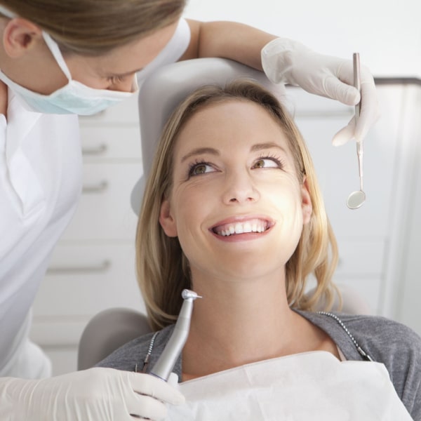 A woman in a dental chair is ready for a procedure