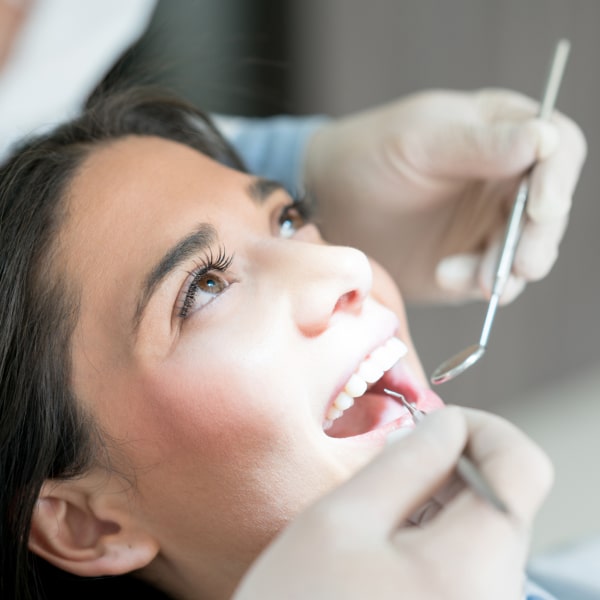 A woman with dark hair is preparing for a dental procedure