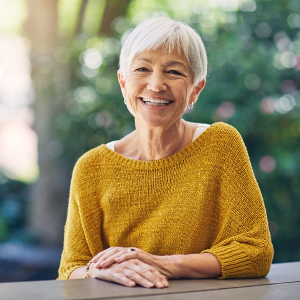 An elderly woman in a mustard jacket