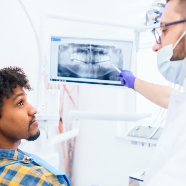 The doctor discusses the image of the jaw with the patient